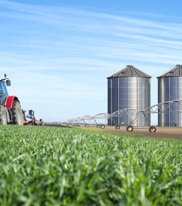 Agriculture and food production concept with tractor machine silos and irrigation system.