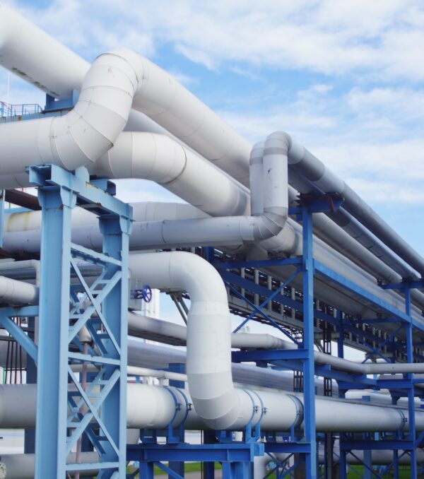 A closeup of industrial pipelines around a factor on a sunny day